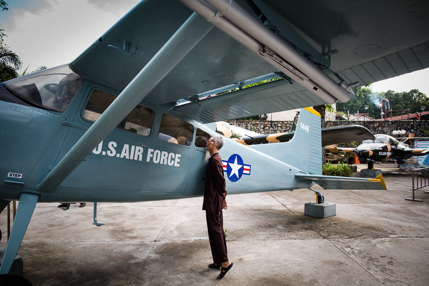 Man peers into a plane artifact at the War Remnants Museum in HCMC. 